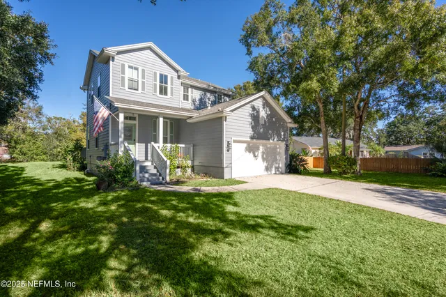 a view of a house with a yard patio and tree