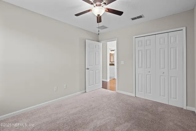 a view of an empty room with a ceiling fan