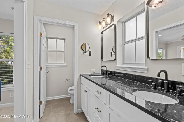a bathroom with double sink and a mirror