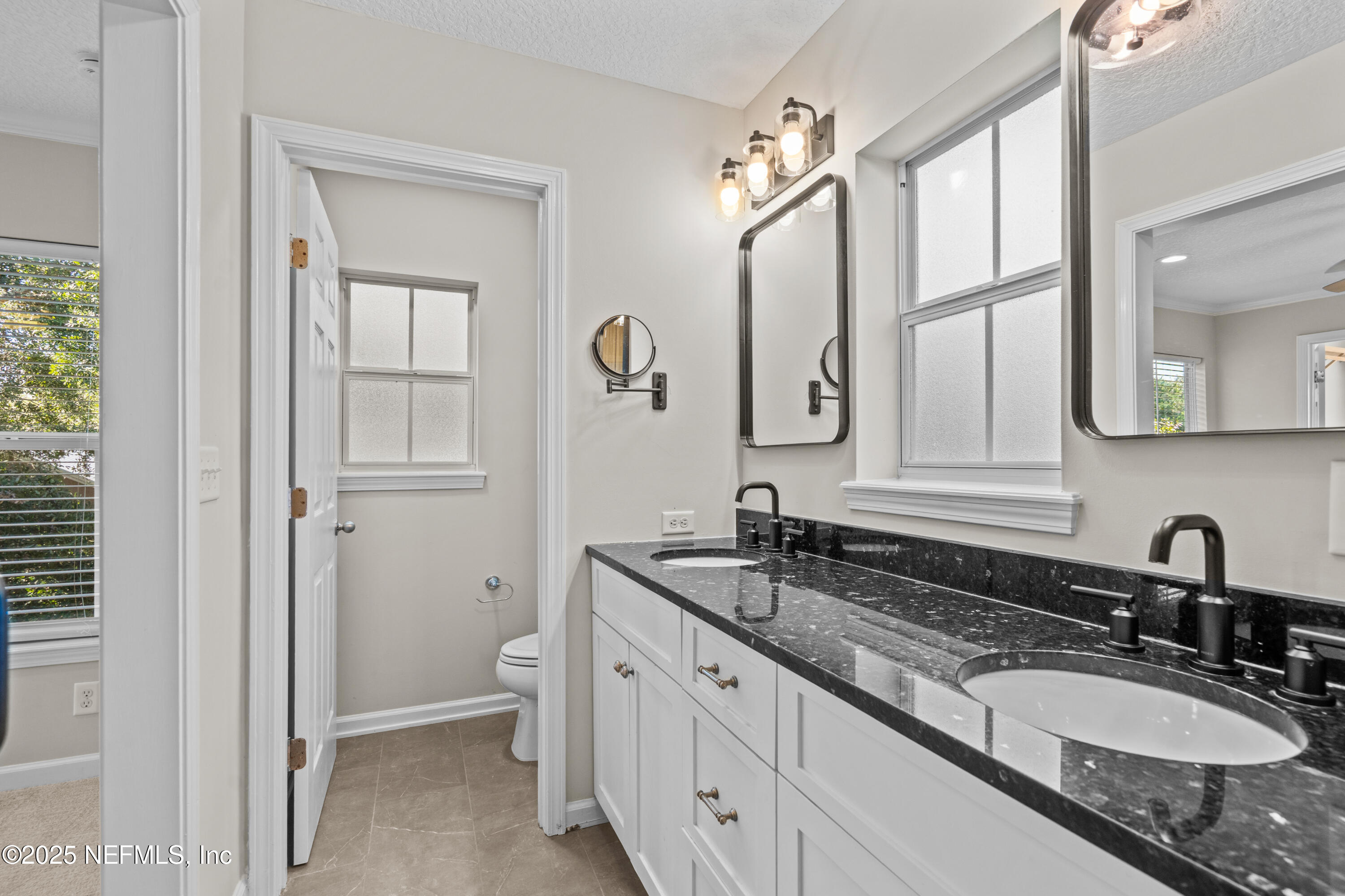 4187 Quail Drive St. Augustine, FL 32084 - Photo 26 of 38 a bathroom with double sink and a mirror