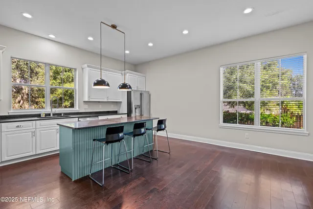 a kitchen with granite countertop a stove a sink and a large window