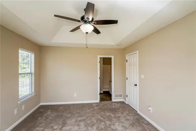 a view of empty room with window and ceiling fan