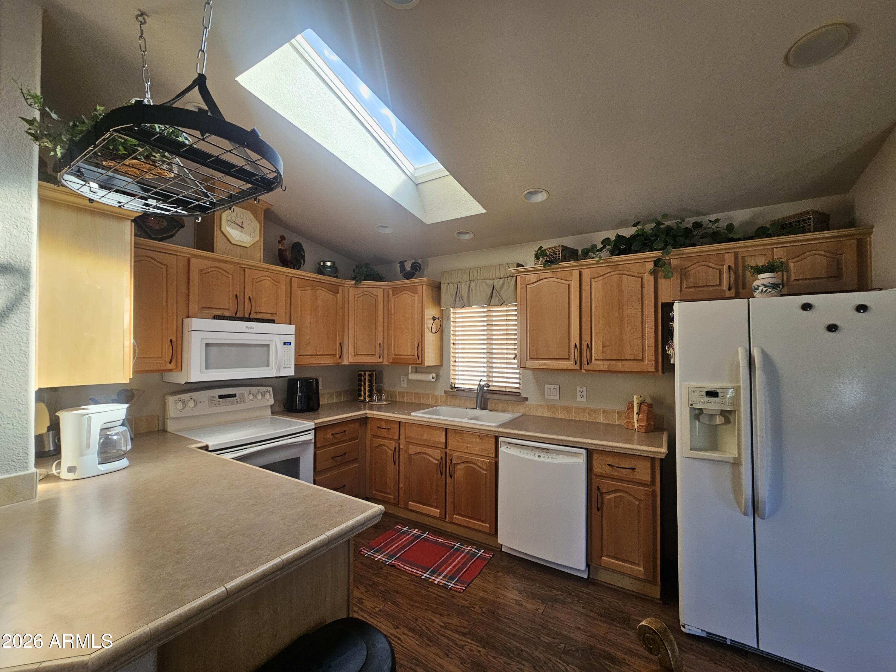 650 North Hawes Road, Unit 4410 Mesa, AZ 85207 - Photo 11 of 40 a kitchen with stainless steel appliances a sink a stove a refrigerator cabinets and wooden floor