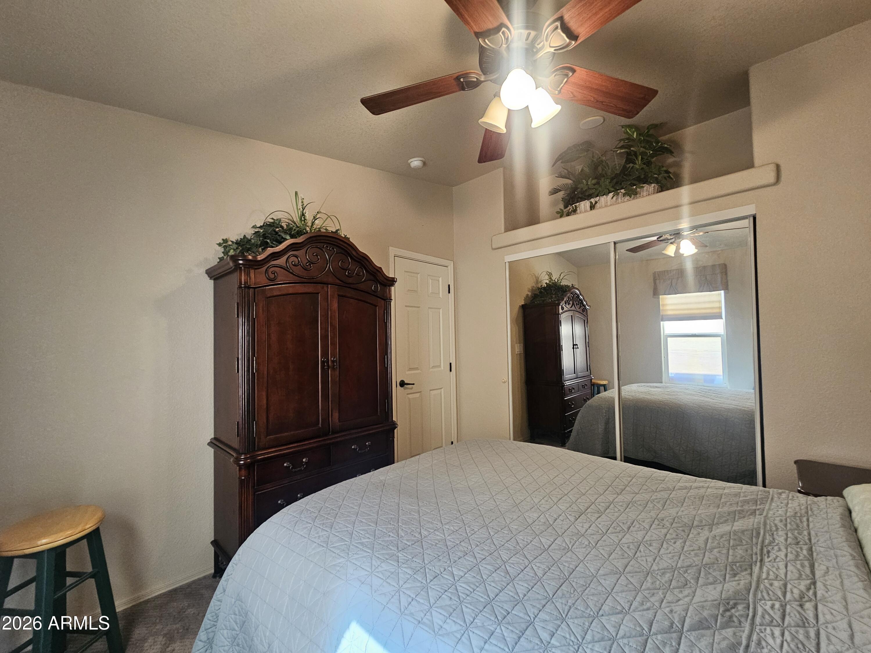 650 North Hawes Road, Unit 4410 Mesa, AZ 85207 - Photo 16 of 40 a bedroom with a bed and a chandelier