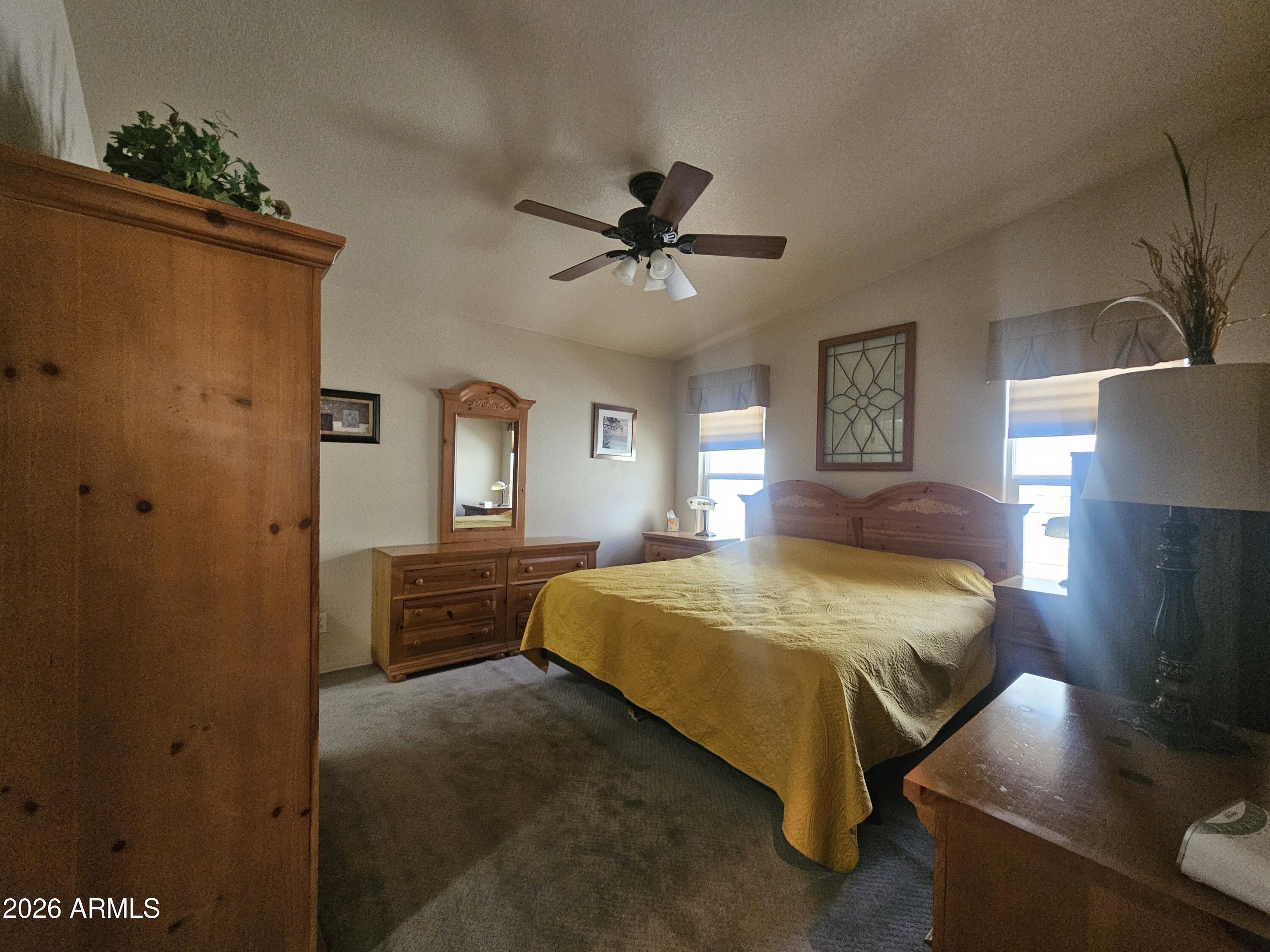 650 North Hawes Road, Unit 4410 Mesa, AZ 85207 - Photo 18 of 40 a bedroom with a bed and a chandelier