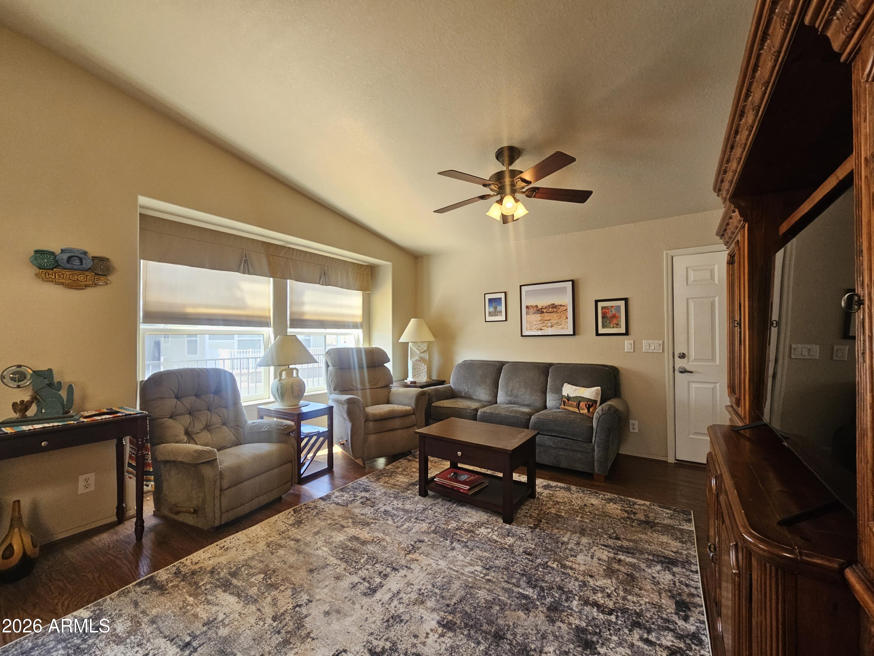 650 North Hawes Road, Unit 4410 Mesa, AZ 85207 - Photo 9 of 40 a living room with furniture a floor to ceiling window and a flat screen tv