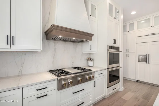 a kitchen with stainless steel appliances granite countertop a refrigerator and a stove top oven