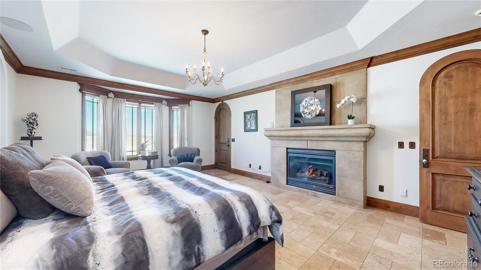 7755 North Moore Road Littleton, CO 80125 - Photo 17 of 46 a spacious bedroom with a bed and a fireplace