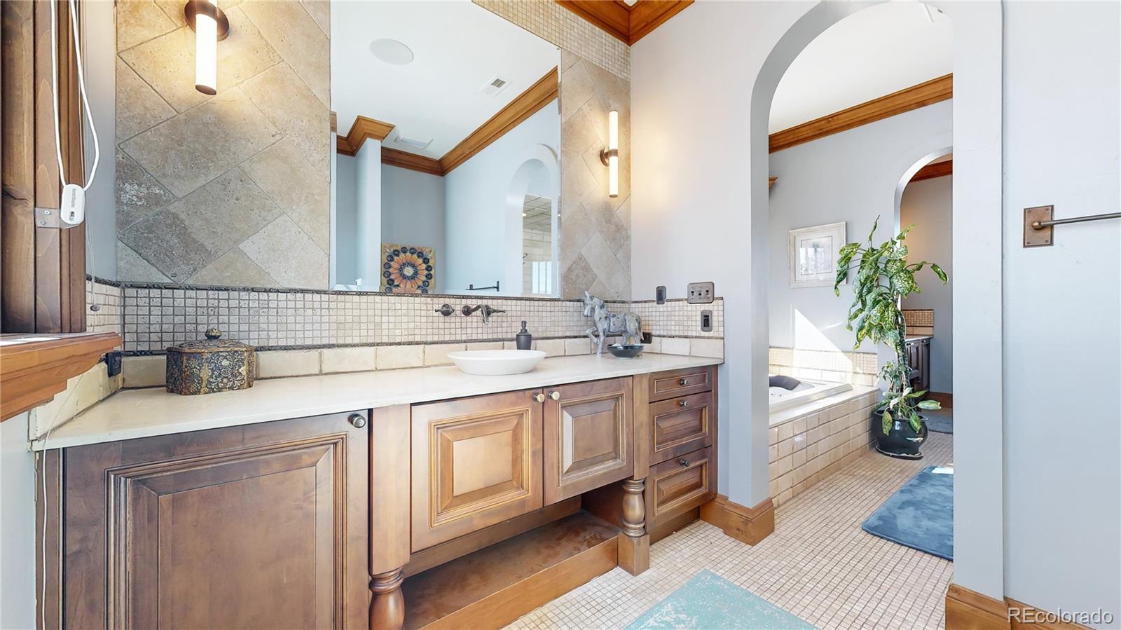 7755 North Moore Road Littleton, CO 80125 - Photo 18 of 46 a spacious bathroom with a granite countertop sink a toilet a and mirror