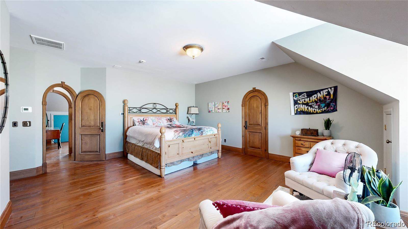 7755 North Moore Road Littleton, CO 80125 - Photo 25 of 46 a bedroom with bed and wooden floor