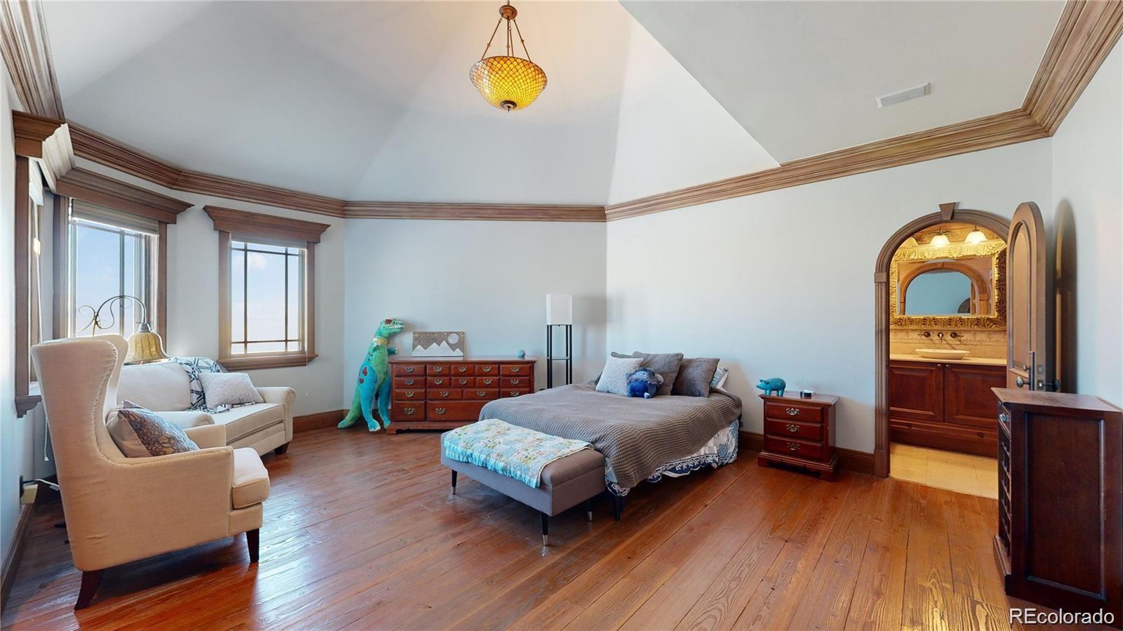 7755 North Moore Road Littleton, CO 80125 - Photo 29 of 46 a bedroom with furniture and a wooden floor