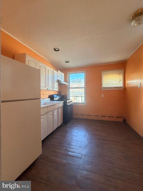 a kitchen with granite countertop wooden floors and white stainless steel appliances