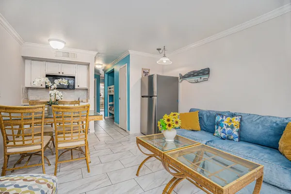 a living room with furniture and a dining table with kitchen view