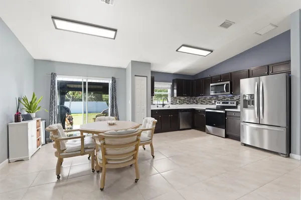 a kitchen with a refrigerator and a dining table