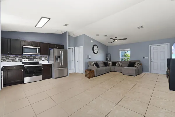 a large bedroom with a bed couches and kitchen view