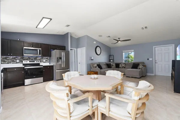 a large kitchen with a table chairs stove and refrigerator