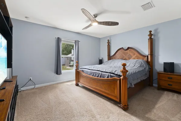 a bedroom with a bed and a tv on the dresser