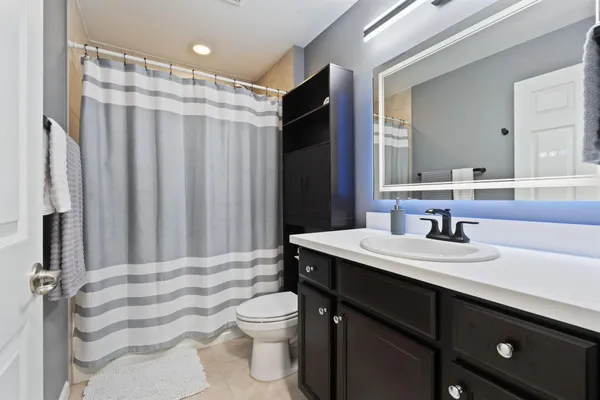 a bathroom with a sink a toilet a mirror and shower