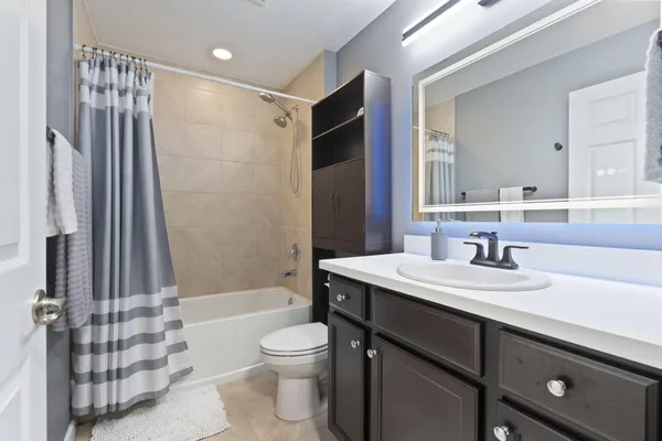 a bathroom with a sink a toilet a mirror and shower