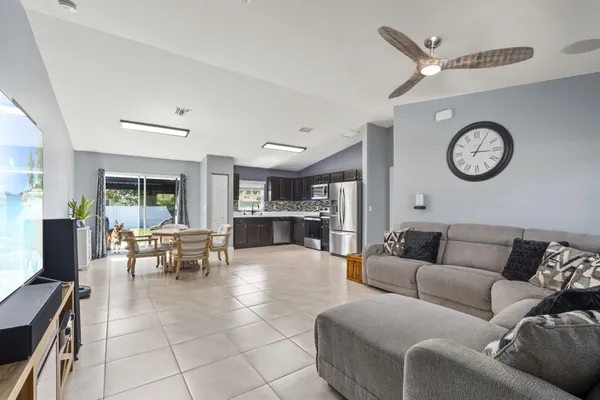 a living room with furniture a clock and a large window