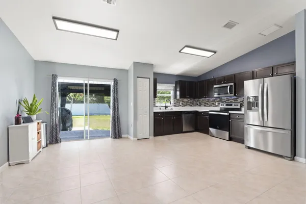 a large kitchen with a refrigerator and a stove top oven