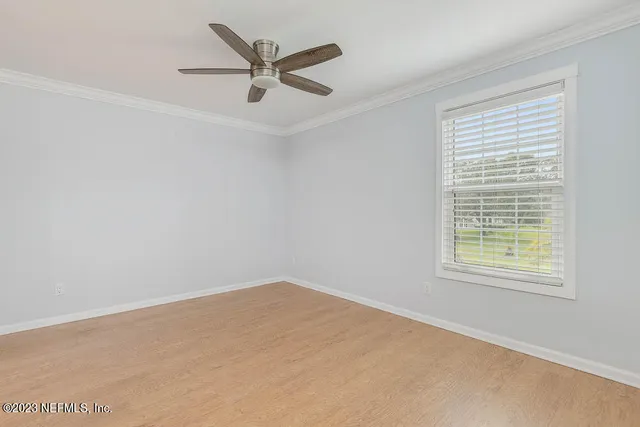 an empty room with a window and a fan
