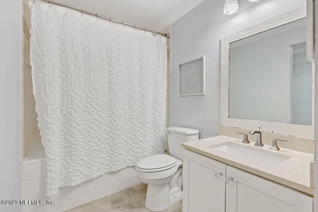 a bathroom with a granite countertop sink a toilet and a mirror