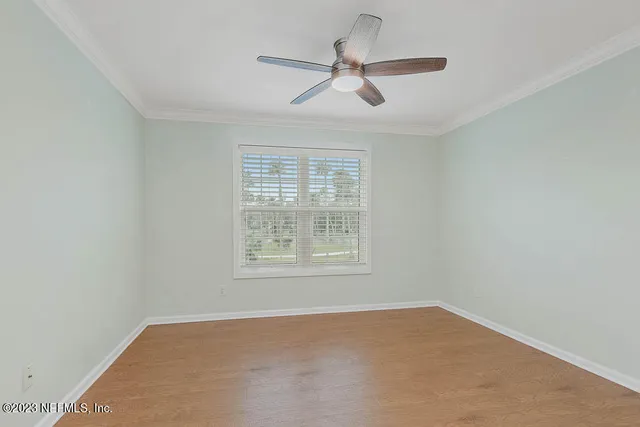 an empty room with a window and a ceiling fan