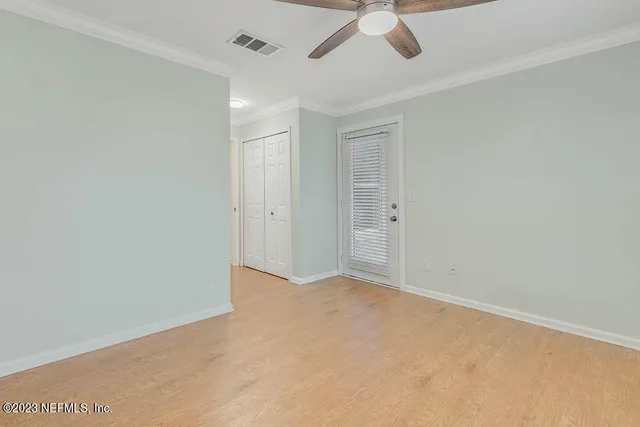 an empty room with chandelier fan