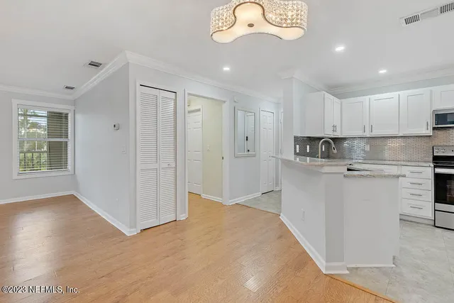 a kitchen with kitchen island white cabinets and stainless steel appliances