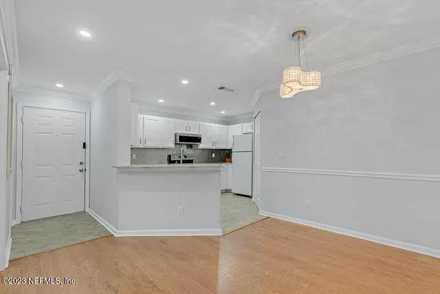 a view of kitchen with refrigerator and window