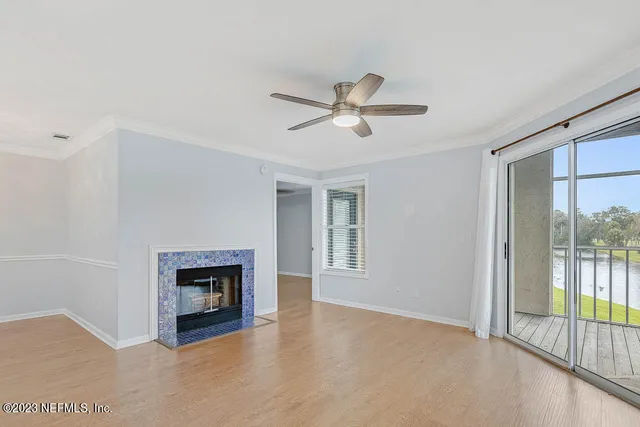 a view of an empty room with a fireplace and a window