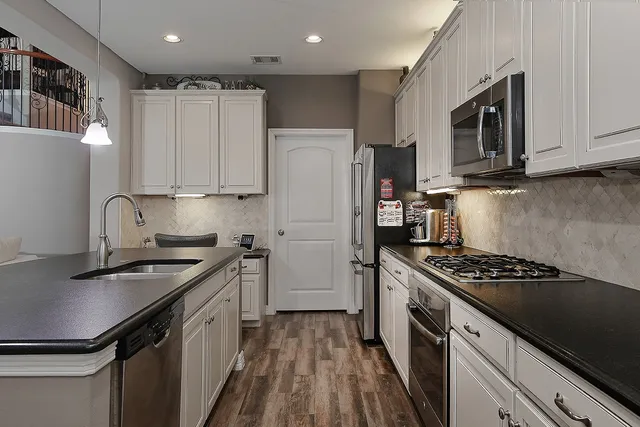 a kitchen with stainless steel appliances a sink stove and refrigerator