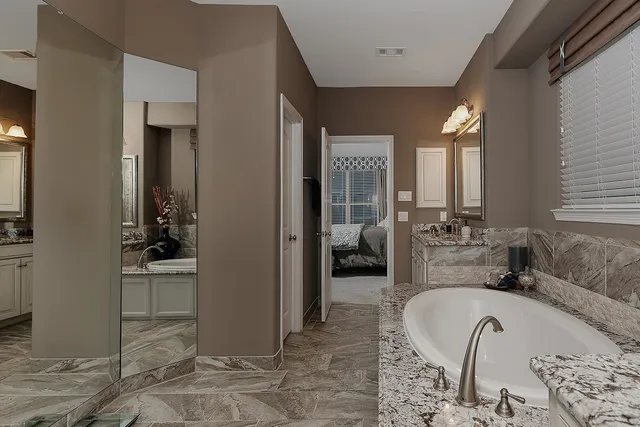 a bathroom with a tub sink and mirror