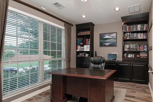 a view of a workspace with furniture and a window