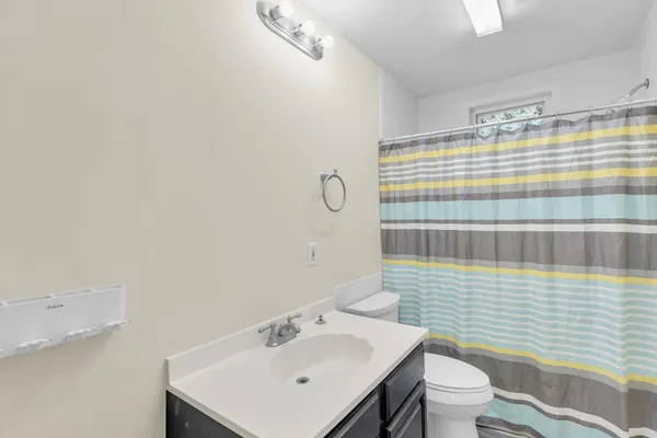 a bathroom with a sink a toilet and shower curtain