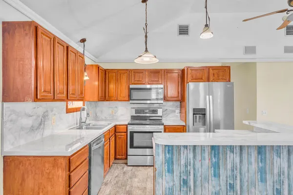 a kitchen with stainless steel appliances granite countertop a sink a stove and a refrigerator