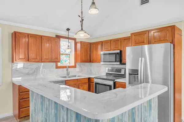 a kitchen with stainless steel appliances granite countertop a sink refrigerator and microwave