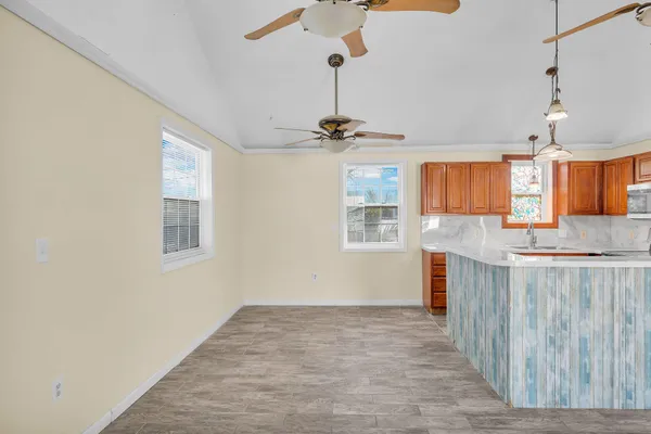 a view of a kitchen with a sink wooden cabinets and a window