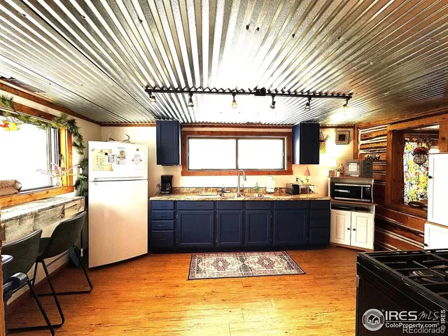 a kitchen with stainless steel appliances granite countertop a refrigerator a stove and a sink