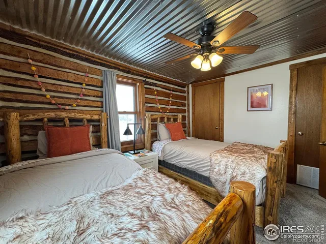 a bed sitting in a spacious bedroom next to a window