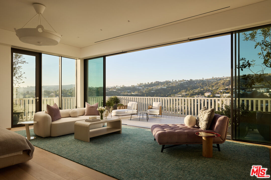 9255 Doheny Road, Unit PH West Hollywood, CA 90069 - Photo 15 of 24 a living room with furniture and a floor to ceiling window