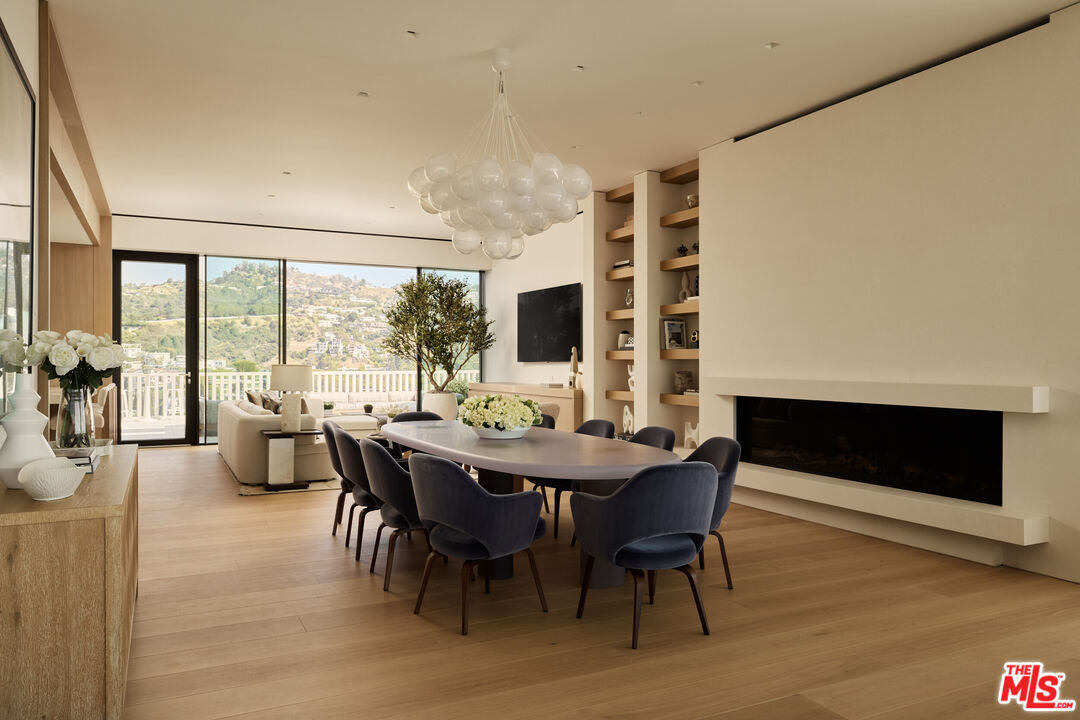 9255 Doheny Road, Unit PH West Hollywood, CA 90069 - Photo 7 of 24 a view of a dining room with furniture window and wooden floor