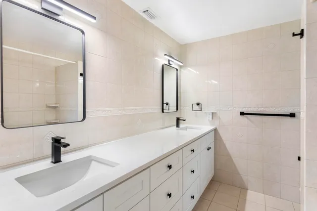 a bathroom with a sink a toilet and a mirror