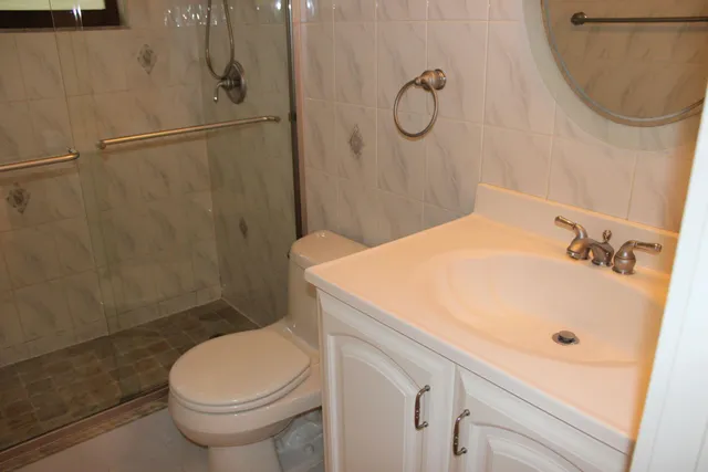 a bathroom with a sink a toilet and shower