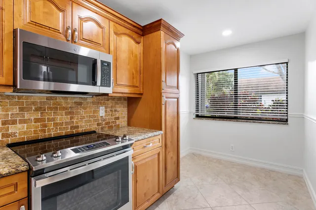 a kitchen with granite countertop cabinets stainless steel appliances and a sink