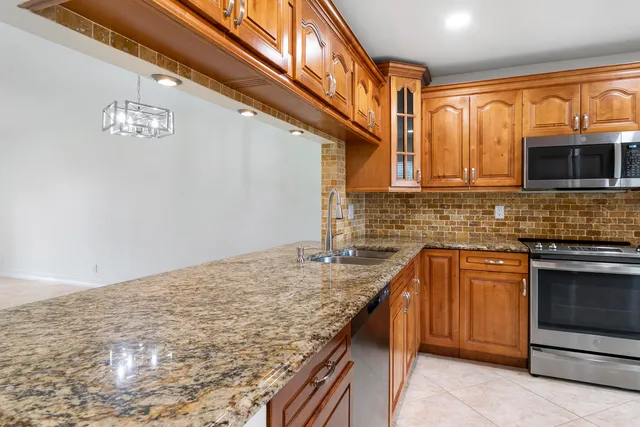 a kitchen with stainless steel appliances granite countertop a sink and a granite counter tops