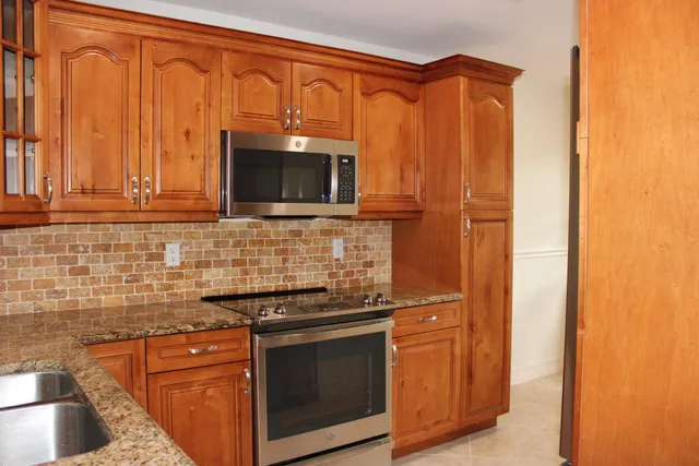 a kitchen with stainless steel appliances granite countertop a stove microwave and refrigerator