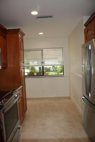 a view of kitchen with window and refrigerator