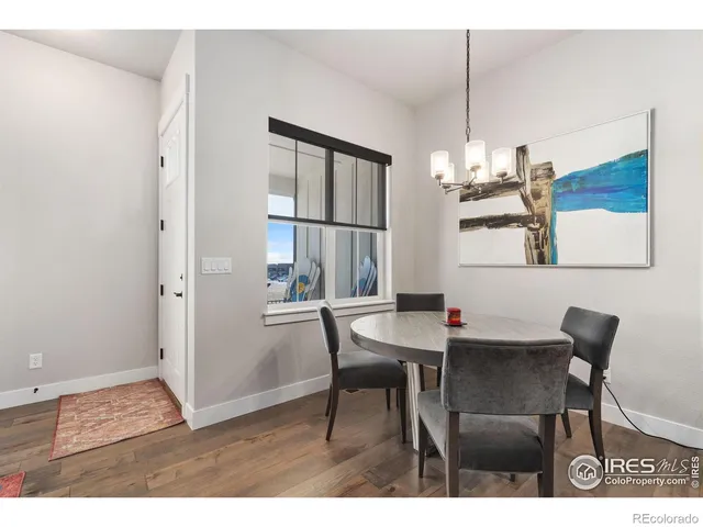 a view of a dining room with furniture a chandelier and wooden floor